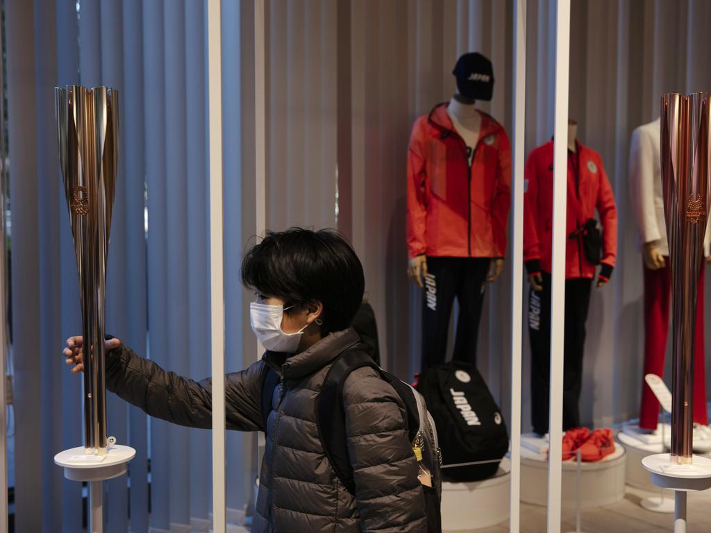 A boy poses with an Olympic torch of the Tokyo 2020 Olympics