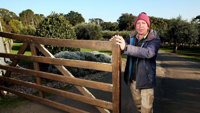 Green Olive at Red Hill co-owner Greg O’Donoghue closing his gate for the second coronavirus lockdown across Melbourne. Picture: Ian Currie