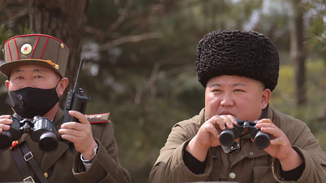 Kim Jong-un (right) overseeing a "long-range artillery" drill in a picture handed out by state media in March 2020. Picture: AFP PHOTO/KCNA VIA KNS.