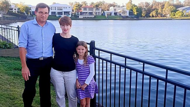 Simon and Sarah Akero with their daughter on the water’s edge at their Sovereign Waters property, where they have been charged a special levy by council for maintenance of the revetment wall.