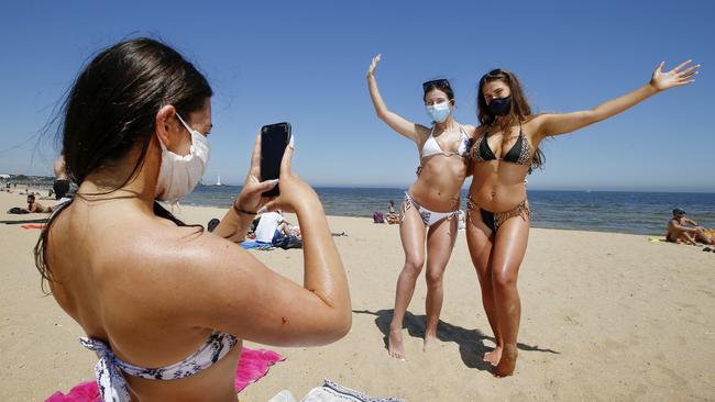 Smile! Mia Caccaviello takes a photo of friends Taniesha Vizas and Lauren Van Velzen at St Kilda beach on Monday. Picture: David Caird