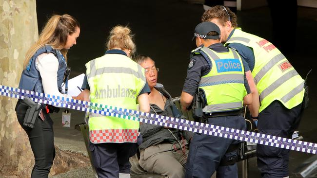 A man is treated by ambulance officers. Picture: Stuart McEvoy.