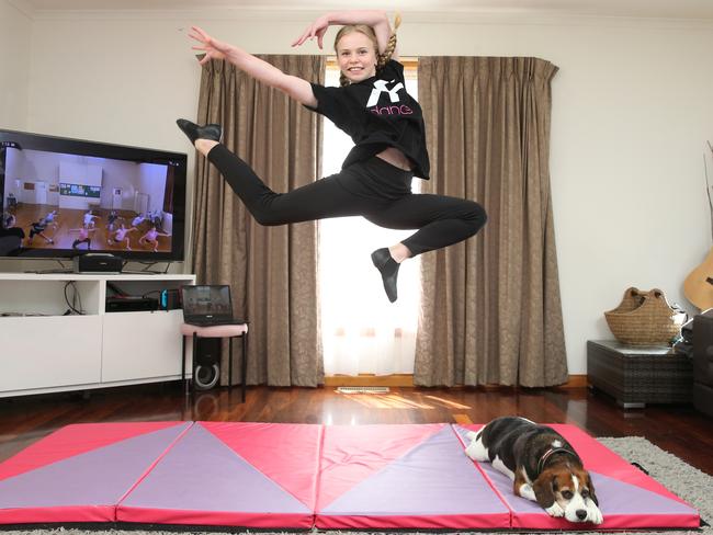 Sophie Hutchinson in her makeshift  home dance studio rehearsing as her pet dog Gus watches. With dance schools closed due to lockdown, Geelong students are re-converting living or garage space into home studios to keep training.Picture: Peter Ristevski