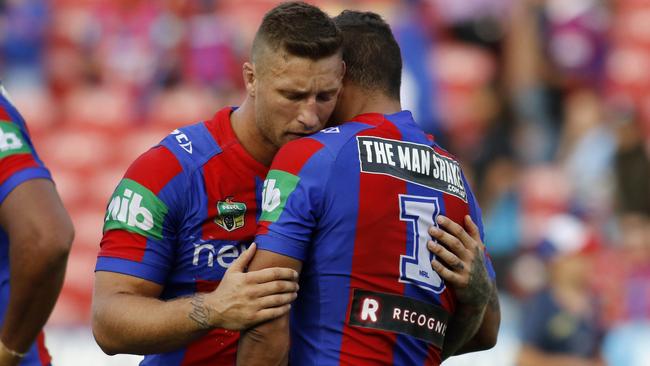 Tariq Sims comforts Dane Gagai after the 62-point thrashing against the Sharks.