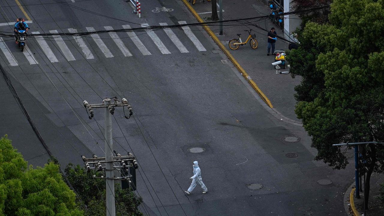 A worker wearing PPE walks on a street during a lockdown in the Jing’an district in Shanghai. Picture: Hector Retamal/AFP