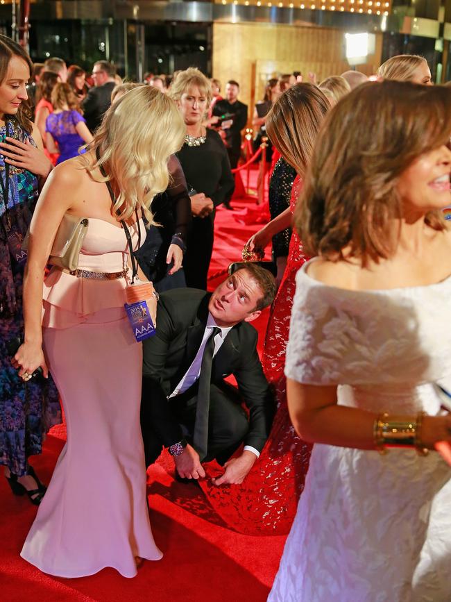 Karl Stefanovic bends down to adjust the dress of Jesinta Campbell as she arrives at the 57th Annual Logie Awards at Crown Palladium. Picture: Getty