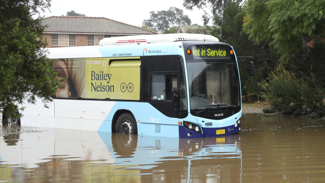 A Busways bus sits stranded in floodwaters on Balmain St in McGraths Hill near Windsor. Picture: John Grainger