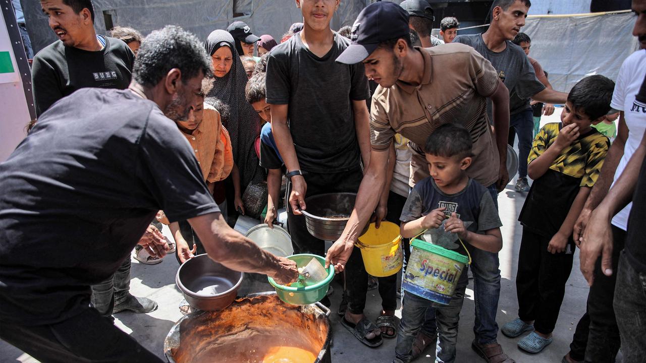 People queue to receive food aid from a kitchen in Gaza. Picture: Omar Al-Qattaa / AFP