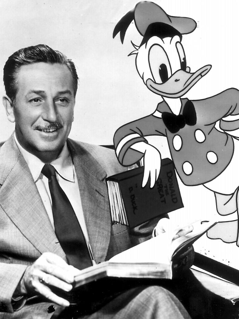 Walt Disney poses with Donald Duck.