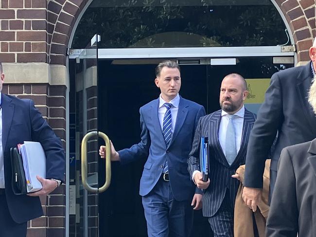 Former NSW police officer Matthew Cameron holds the door handle as he leaves Manly Local Court on Monday. Picture The Daily Telegraph