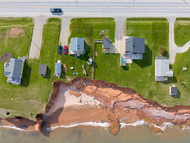 An aerial view shows coastal erosion around a home in the Magdalen Islands of Quebec, Canada. Footpaths are caving in, cliffs are receding and the sand dunes are disappearing on the small archipelago in the Gulf of Saint Lawrence, leaving homes vulnerable to the lashing waves. Picture: Sebastien St-Jean / AFP