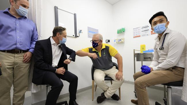 Scott Morrison elbow bumps Greg Hunt after receiving a Covid-19 vaccination from Doctor Jesse Li, right, at Castle Hill Medical Centre on Sunday. Picture: Getty Images