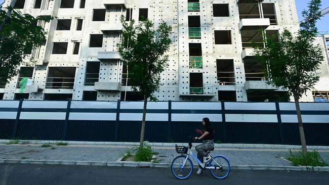 A woman rides past a development of property developer Country Garden in Beijing.