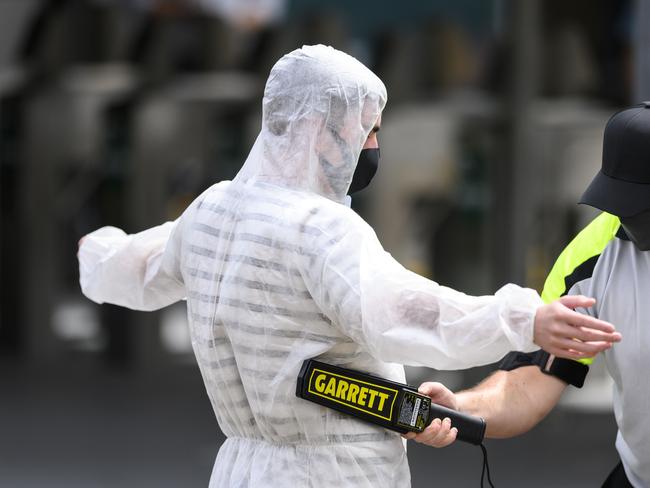 A cricket fan adds a full body protective suit to his face mask as he enters the SCG yesterday. Picture: Darren Leigh Roberts