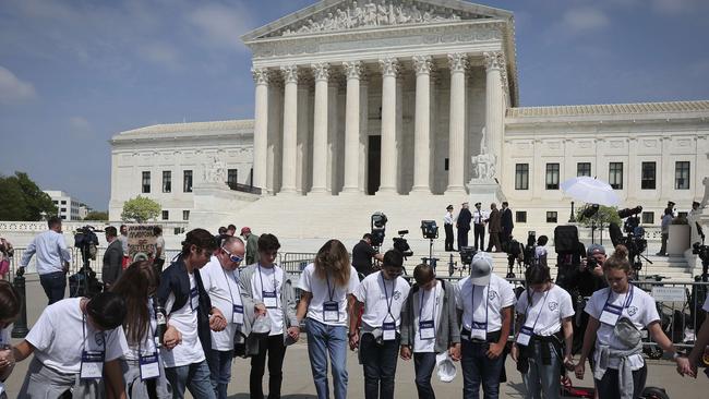 Students and parents from the Wickenberg Christian Academy, in Wickenberg, Arizona, pray in front of the US Supreme Court Building after the draft report was leaked. Picture: AFP.