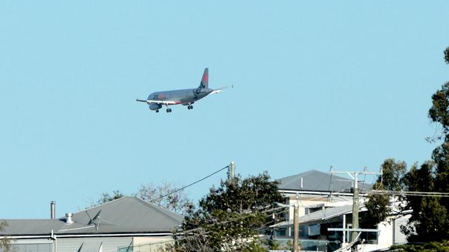 A Jetstar plane flying over Hamilton Hill heading towards Brisbane Airport