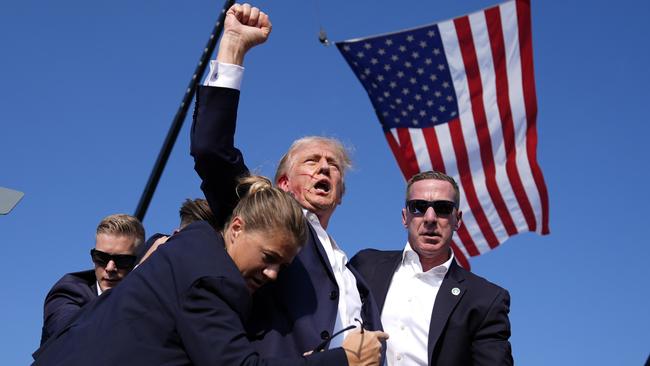 Secret Service agents surround a defiant Donald Trump after he was shot at a Pennsylvania rally. Picture: AP