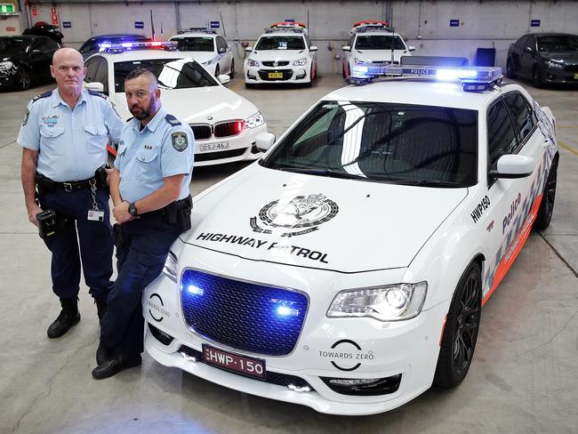 Senior Constable John Larkins and Leading Senior Constable Darrin Hooper with the BMW (background) and the Chrysler. Picture: Sam Ruttyn