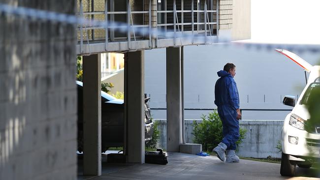 A member of the forensic police team searches the area near where a woman’s body was found in Toowong. Pic: Jack Tran