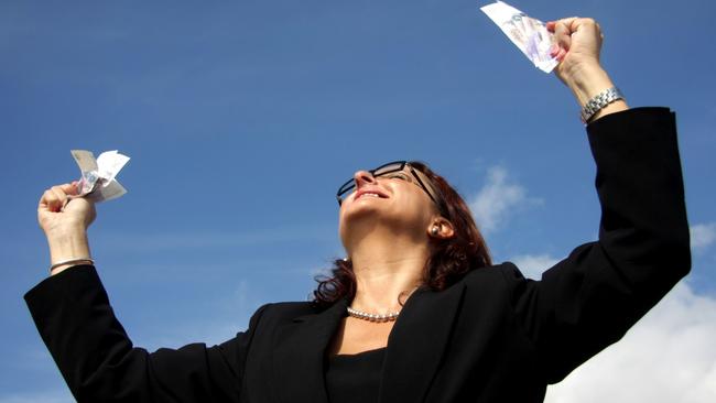 Feeling of success. Generic image of a happy woman looking up at blue sky, holding lottery tickets and smiling.