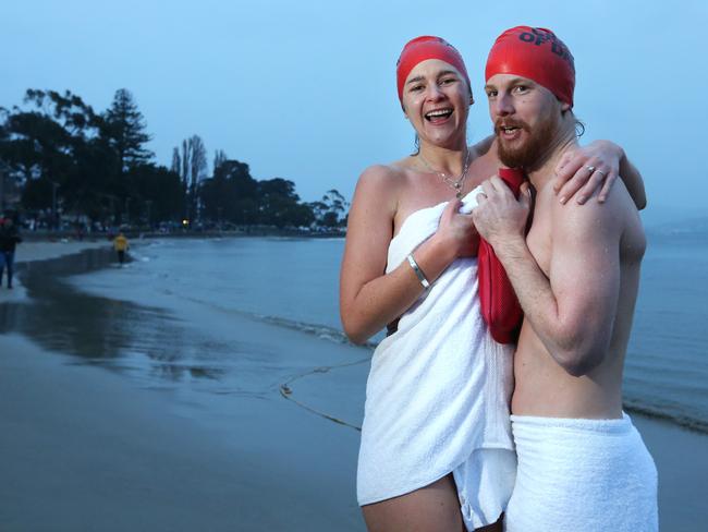 Samantha Hawker and Chris McGrath, from New South Wales, warm up with a hot water bottle after the swim. Picture: NIKKI DAVIS-JONES