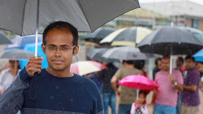 Rajesh Subramanian and other Akuna Vista residents brave the rain to protest against the proposed ‘Nirimba Marana’ name change for part of the suburb of Schofields. Picture: Angelo Velardo