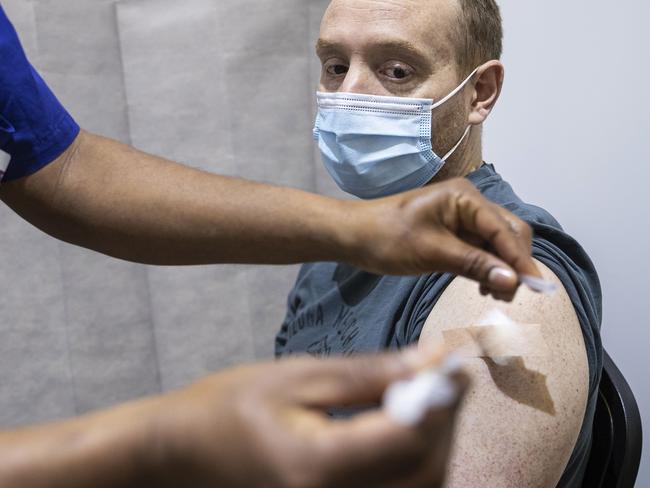 MELBOURNE, AUSTRALIA - JULY 20: A man receives a COVID-19 vaccine inside the Melbourne Showgrounds COVID-19 Vaccination Centre on July 20, 2021 in Melbourne, Australia. Premier Daniel Andrews has announced a 7 day extension on the lockdown in Victoria, as the state continues to record new community COVID-19 cases and work to stop the spread of the highly infectious delta coronavirus strain in the community. (Photo by Daniel Pockett/Getty Images)