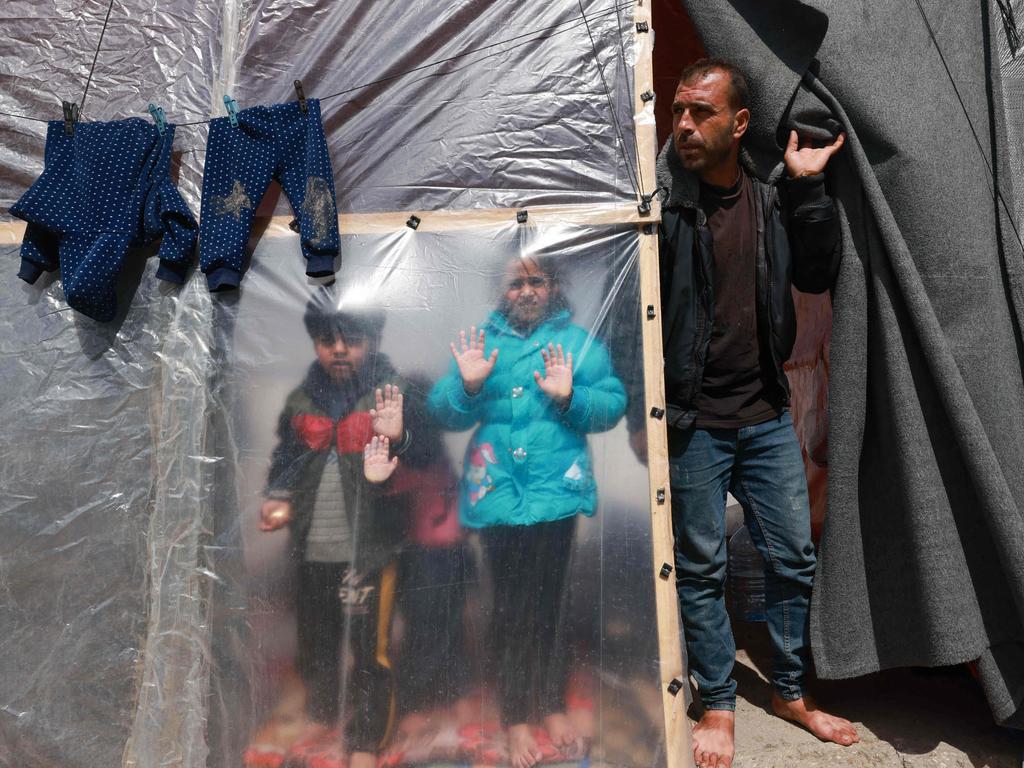 Displaced Palestinian children and a man look out from their tent in Rafah in the southern Gaza Strip. Picture: Mohammed Abed/AFP