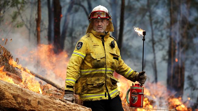 An RFS member during a controlled burn during milder weather as bushfires surrounded Spencer on the Hawkesbury River. Picture: Jane Dempster