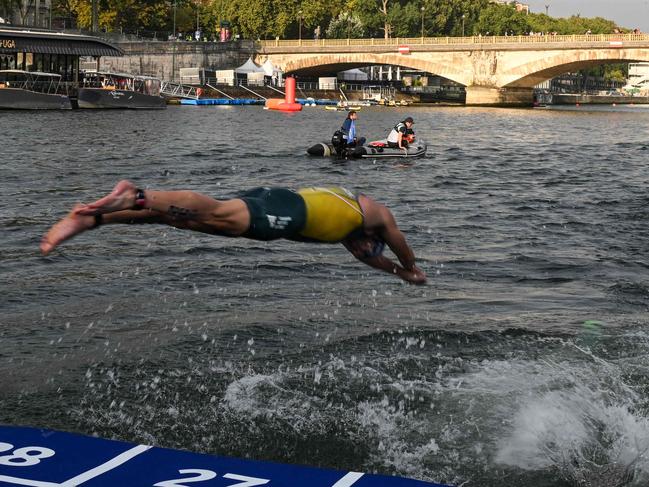 (FILES) Triathlon athlete dives in the Seine river with The Eiffel Tower in the background during the men's 2023 World Triathlon Olympic Games Test Event in Paris, on August 18, 2023. From August 17 to 20, 2023, Paris 2024 is organising four triathlon events to test several arrangements, such as the sports operations, one year before the Paris 2024 Olympic and Paralympic Games. The swim familiarisation event follows the cancellation on August 6 of the pre-Olympics test swimming competition due to excessive pollution which forced organisers to cancel the pre-Olympics event. (Photo by Bertrand GUAY / AFP)