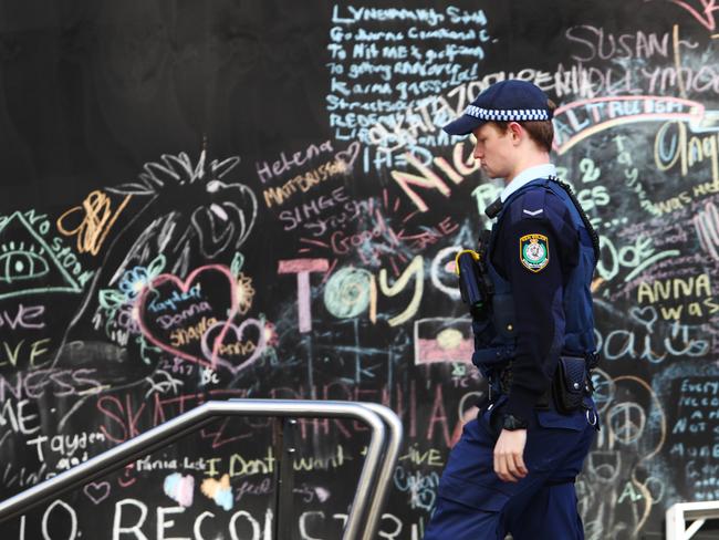 A police officer walks past the Martin Place tent city today. Picture: Hollie Adams/The Australian