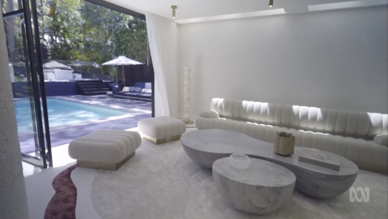 The loungeroom features a white bouclé couch and white bamboo silk rug. Picture: ABC