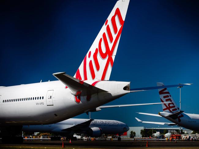 Virgin Australia aircraft are seen parked on the tarmac at Brisbane International airport on April 21, 2020. - Cash-strapped Virgin Australia collapsed on April 21, making it the largest carrier yet to buckle under the strain of the coronavirus pandemic, which has ravaged the global airline industry. (Photo by Patrick HAMILTON / AFP)