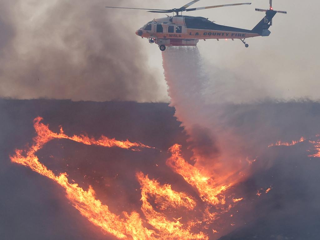 A firefighting helicopter drops water as the Hughes Fire burns north of Los Angeles. Picture: AFP