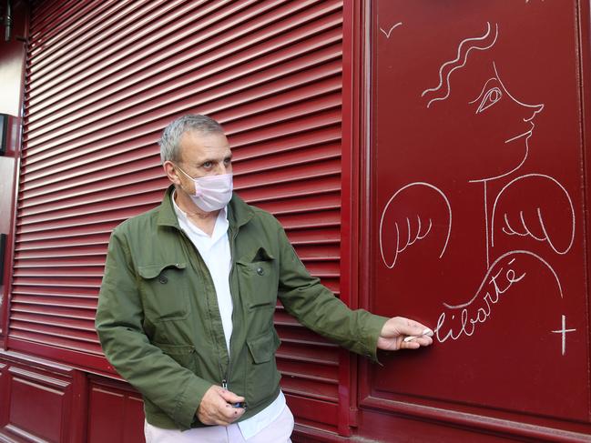 Jean-Charles de Castelbajac draws on a restaurant wall in Paris as France begins a new lockdown. Picture: Getty Images