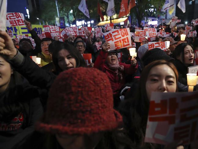 South Koreans shout slogans during an anti-president rally in downtown Seoul, South Korea, Saturday, Oct. 29, 2016. Thousands of South Koreans took to the streets of the capital on Saturday calling for increasingly unpopular President Park Geun-hye to step down over allegations that she let an old friend, the daughter of a religious cult leader, interfere in important state affairs. (AP Photo/Lee Jin-man)