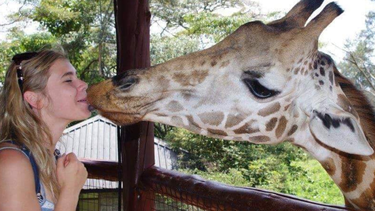 Elly Warren, who died mysteriously in Tofo, Mozambique in November 2016, pictured with a giraffe on an earlier trip to Africa. Picture: Supplied.