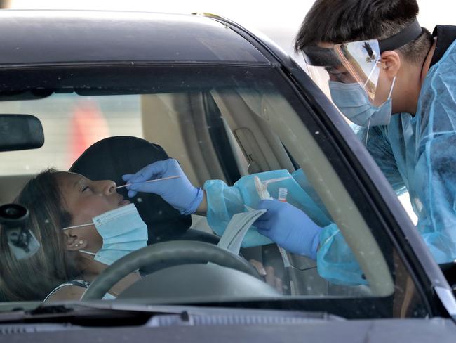 In this June 27, 2020, photo, people are tested in their in vehicles in Phoenix's western neighborhood of Maryvale in Phoenix for free COVID-19 tests organized by Equality Health Foundation, which focuses on care in underserved communities. Arizona's Republican governor shut down bars, movie theaters, gyms and water parks Monday, June 29, and leaders in several states ordered residents to wear masks in public in a dramatic course reversal amid an alarming resurgence of coronavirus cases nationwide. (AP Photo/Matt York)