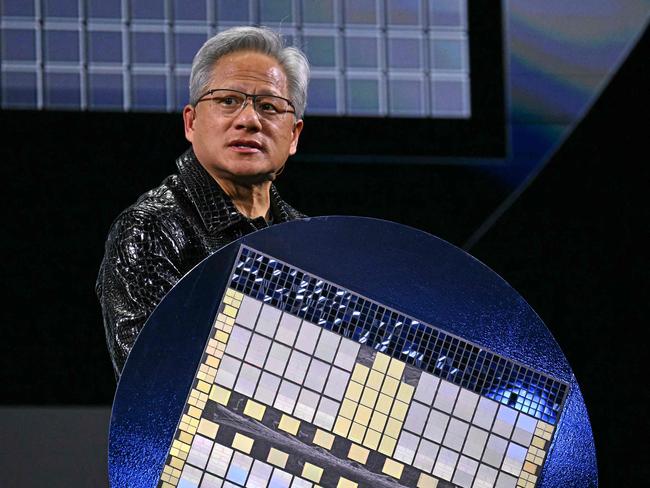 (FILES) Nvidia CEO Jensen Huang holds a Grace Blackwell NVLink72 as he delivers a keynote address at the Consumer Electronics Show (CES) in Las Vegas, Nevada on January 6, 2025. Nvidia, the chipmaker at the center of an expected AI boom, sank nearly 17 percent, slicing some $589 billion in market value on January 27, 2025. The S&P 500 also dropped, while the Dow finished higher. The Nasdaq slumped more than three percent as revelations about a new apparently low-cost Chinse artificial intelligence venture battered Nvidia and other US AI shares. The chatbot developed by DeepSeek, a startup based in the eastern Chinese city of Hangzhou, has apparently shown the ability to match the capacity of US AI pace-setters for a fraction of the investments made by American companies. (Photo by Patrick T. Fallon / AFP)