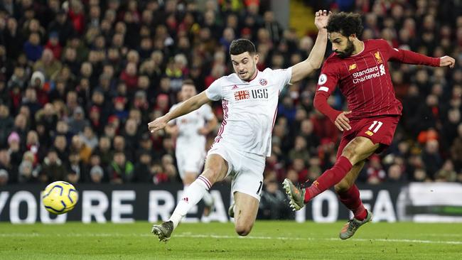 Sheffield United’s David McGoldrick, left, tries to block a shot from Liverpool’s Mohamed Salah at Anfield. Picture: AP