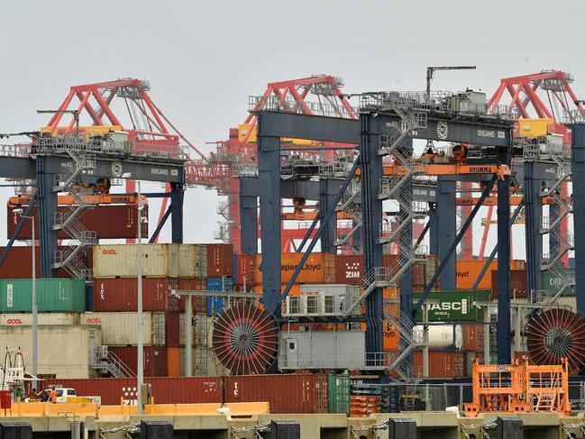 Workers prepare to load containers on a cargo ship at the Port Botany in Sydney on December 2, 2020. (Photo by Saeed KHAN / AFP)