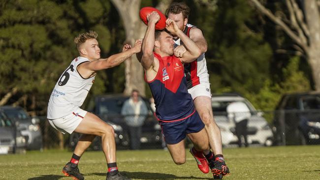 SFNL: Luke Tapscott gets a handball away under pressure for Chelsea Heights. Picture: Valeriu Campan