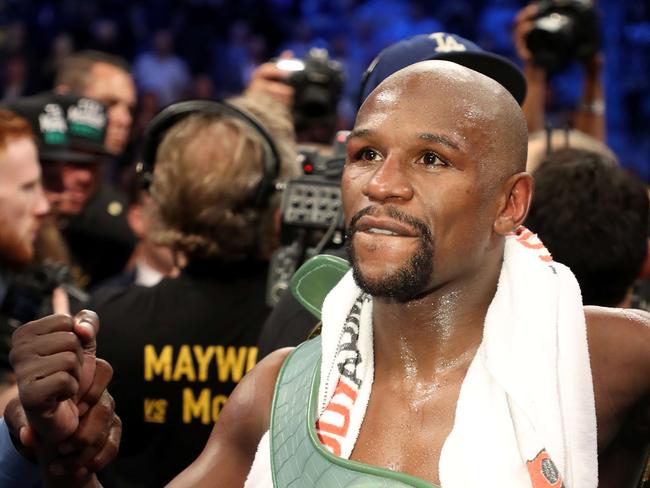 Floyd Mayweather Jr. celebrates with the WBC Money Belt after his TKO of Conor McGregor.