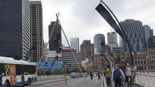 Extinction Rebellion protester Sophie Thompson hangs from her bamboo tripod on Brisbane’s Victoria Bridge.