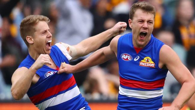 Jack Macrae and Lachie Hunter celebrate a goal as Western Bulldogs stormed over Hawthorn on Sunday. Picture: Scott Barbour/AFL Photos/Getty Images.