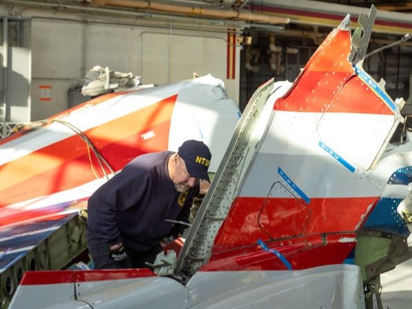 An investigator inspects the wreckage of an American Airlines plane which crashed after colliding with a Black Hawk helicopter. Picture: NTSB