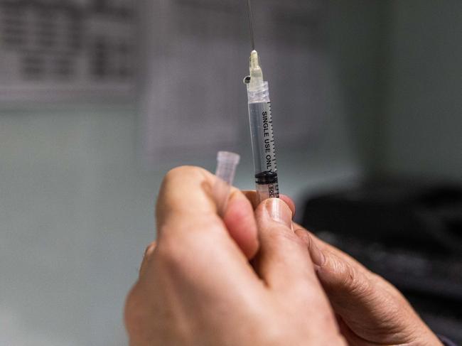 MELBOURNE, AUSTRALIA - JULY 11: A pharmacist prepares a COVID-19 vaccination booster shot for a customer at the Exhibition Pharmacy on July 11, 2022 in Melbourne, Australia. More Australians are now eligible to receive a fourth dose of a COVID-19 vaccine, after the Australian Technical Advisory Group on Immunisation (ATAGI) approved people aged 30 and above can access additional booster shots from Monday 11 July. While over 30s are now eligible for an additional dose if they choose, health authorities are strongly urging people over 50 to get the fourth COVID-19 vaccine booster and for people to wear masks indoors in public as coronavirus infections continue driven by Omicron subvariants. (Photo by Asanka Ratnayake/Getty Images)