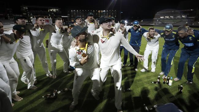 Nathan Lyon and Steve Smith celebrate with teammates while singing the team song on the pitch after Australia claimed victory to retain the Ashes. Picture: Getty