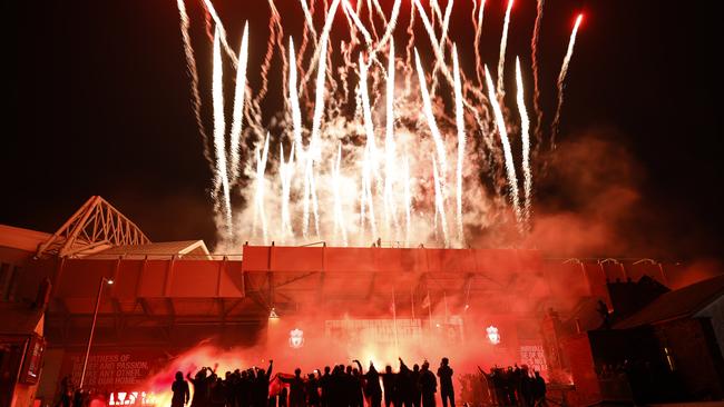 Liverpool fans celebrate outside Anfield stadium in front of fireworks from inside the stadium as Liverpool lift the Premier League trophy. Picture: Getty Images
