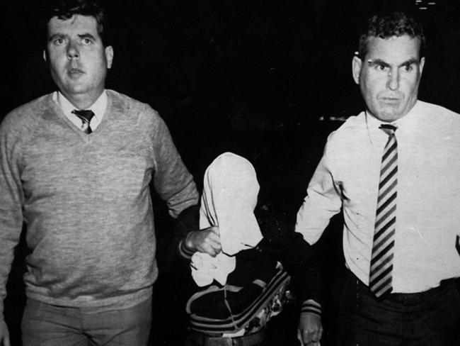 Stephen “Shorty” Jamieson being escorted by NSW police from Southport police station on his way to Brisbane Airport in 1988.